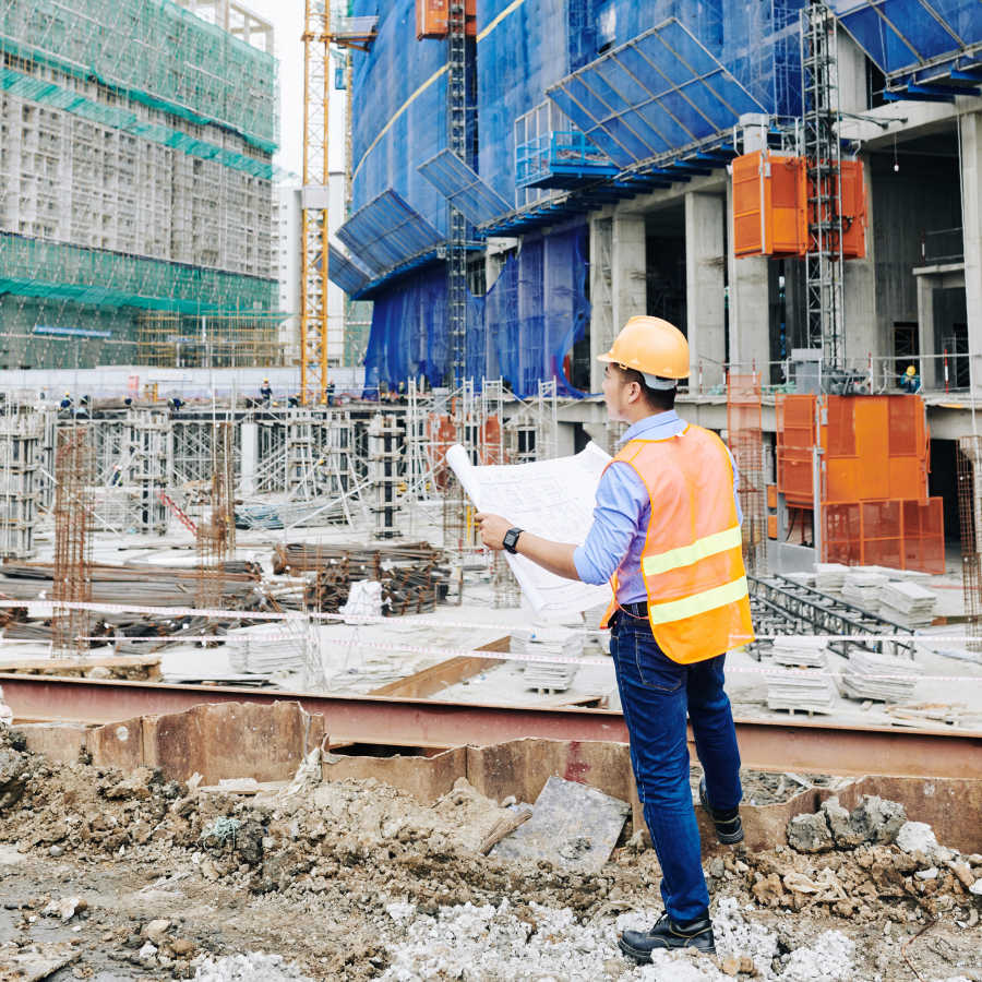 Ingénieur en stabilité analysant un chantier de construction et la structure d’un bâtiment