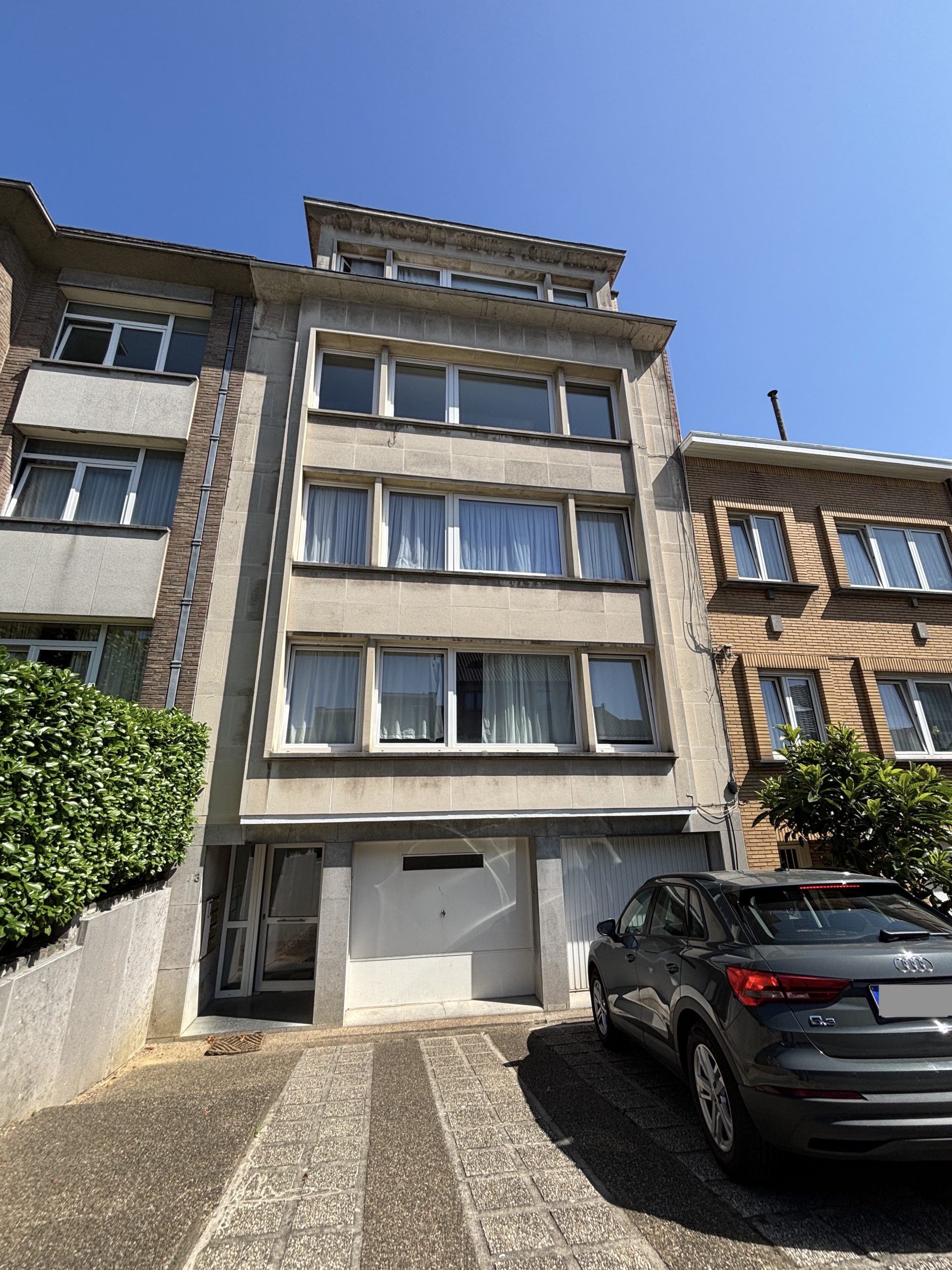 Immeuble en copropriété à Anderlecht présentant des fissures verticales en façade